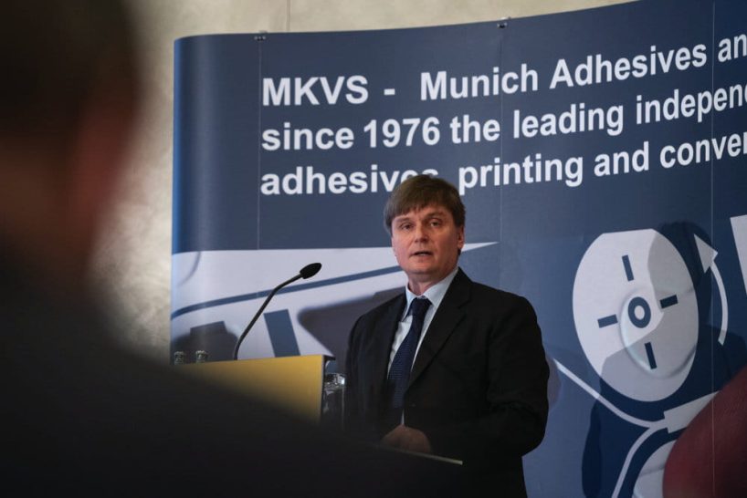 Man in a suit at a lectern.