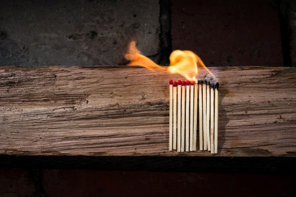 Burning matches on a wooden beam.