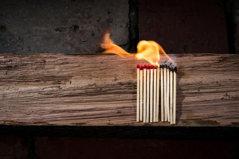 Burning matches on a wooden beam.