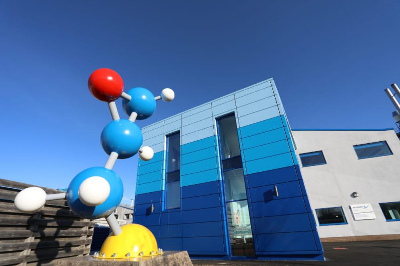 Blue building with globe sculpture in front.