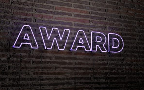 Luminous sign with award lettering on a wall.