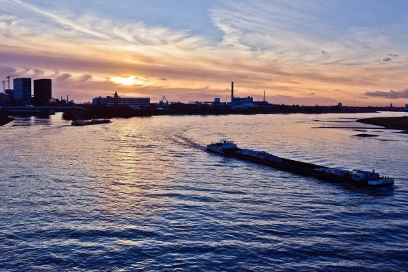 Symbol: The skyline of Düsseldorf with a cargo ship on the Rhine.