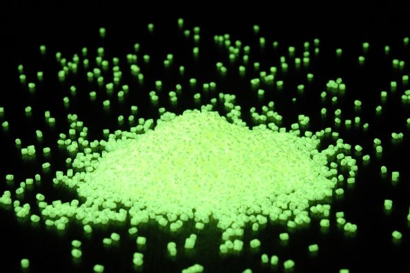 Green glowing granules against a black background.