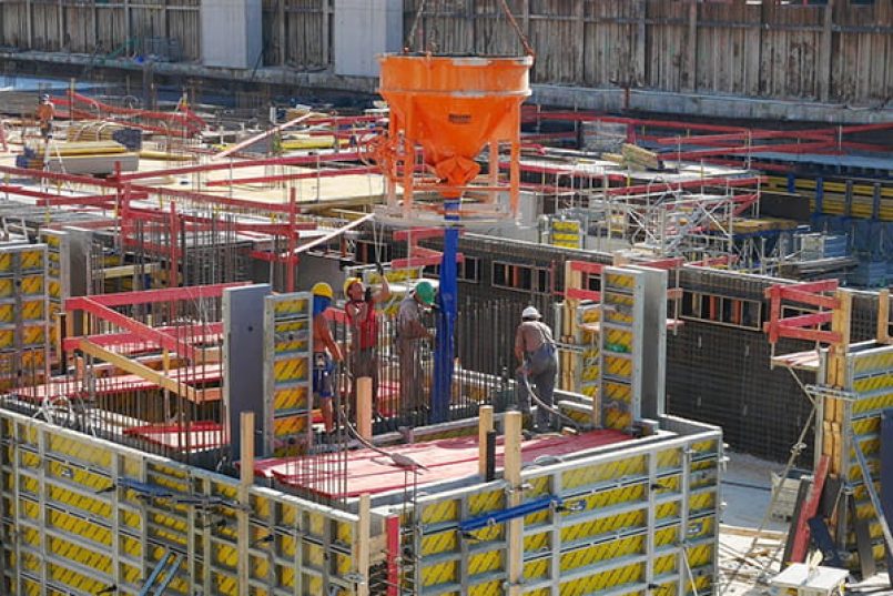 Concrete is poured at a construction site.