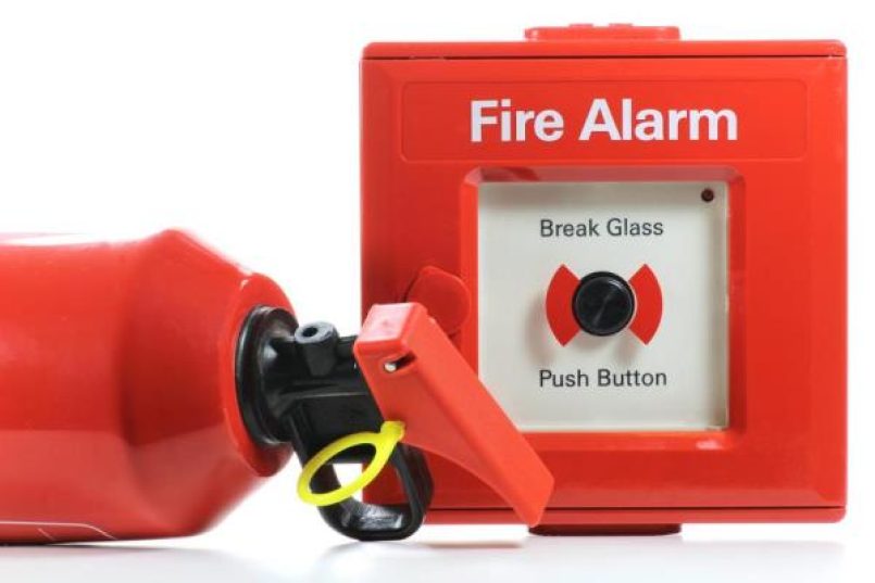 A fire alarm button and a fire extinguisher.