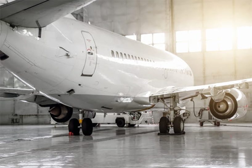 A white painted aircraft in a hangar.