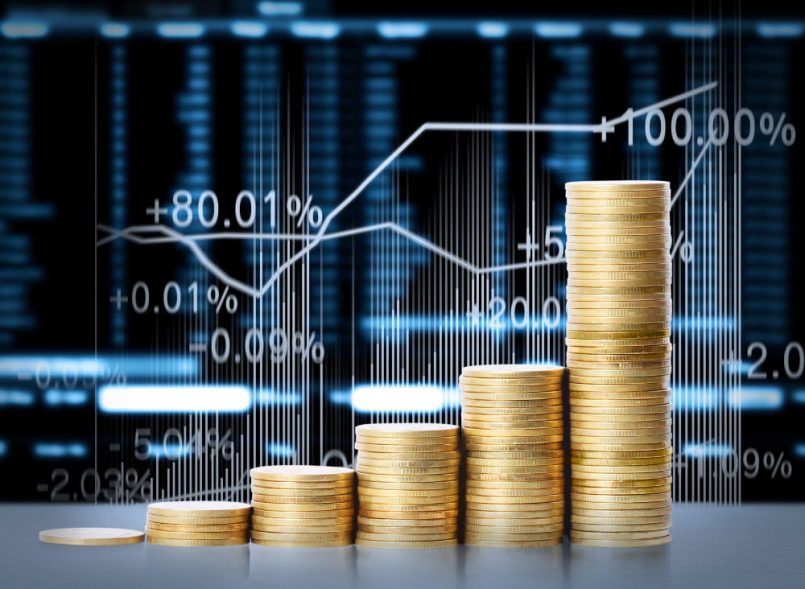 A graphic with stock market prices and money coins in the foreground for illustration.