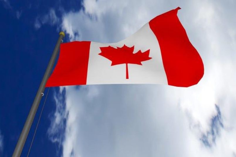 The Canadian flag against a blue sky.