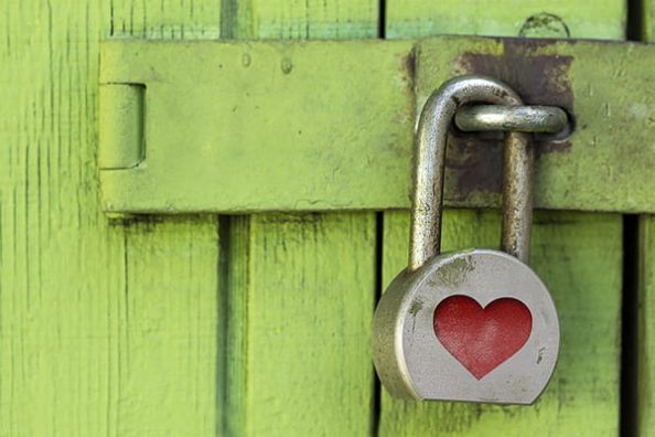 A padlock in front of a coated wooden door.