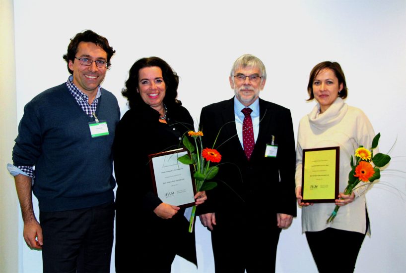 Two men and two women with flowers and certificates.