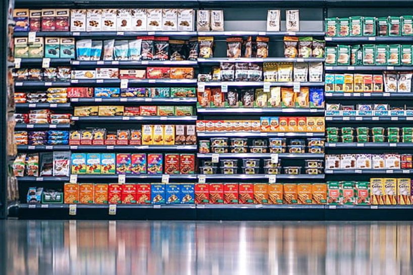 A supermarket shelf with a wide variety of food packaging as a symbolic image.