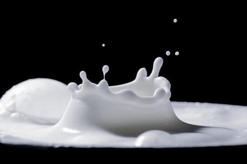 Milk drips onto a black background.