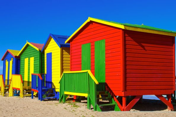 Colourful wooden houses on a beach.