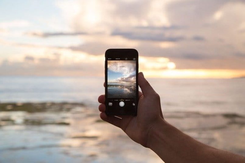 A mobile phone in the sunset as a symbolic image.