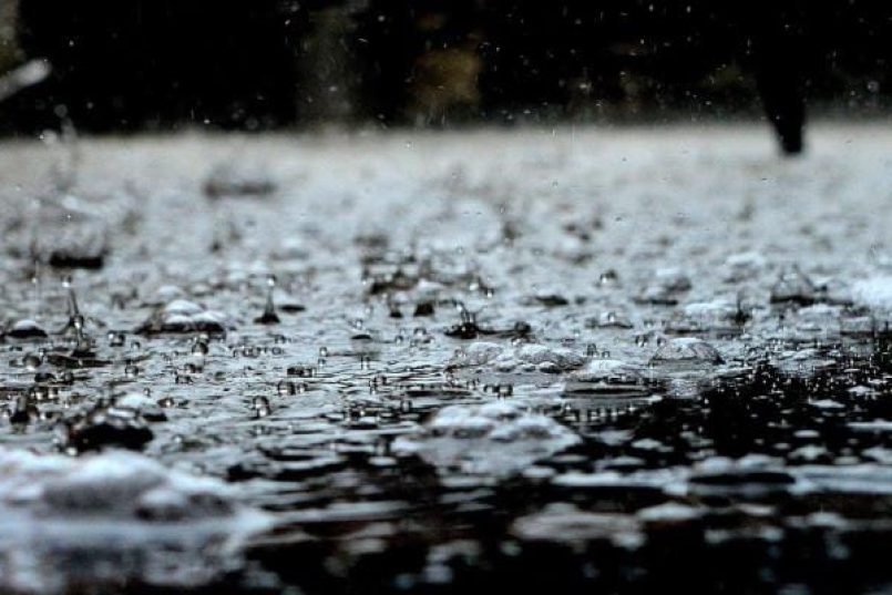 Rain pattering on a black surface as a symbolic image.