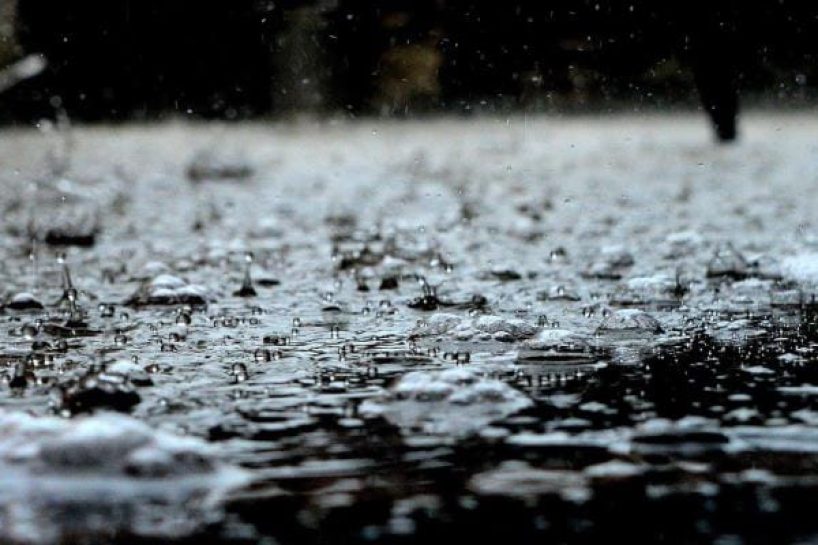 Rain pattering on a black surface as a symbolic image.