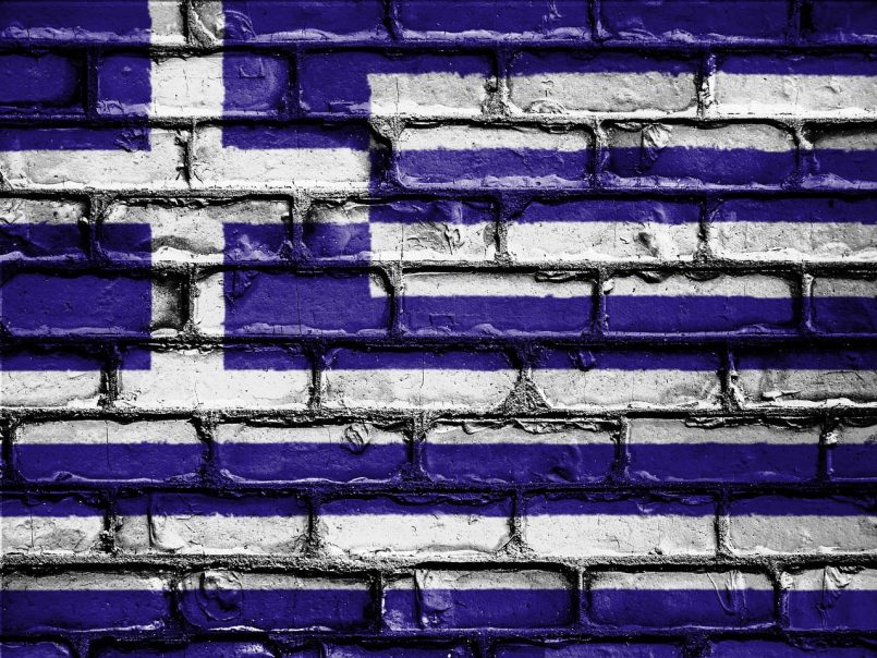 Greek flag on a brick facade.