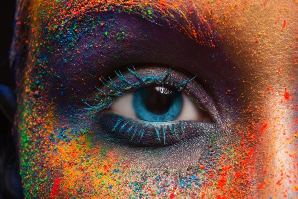 Human eye with coloured powder all around.