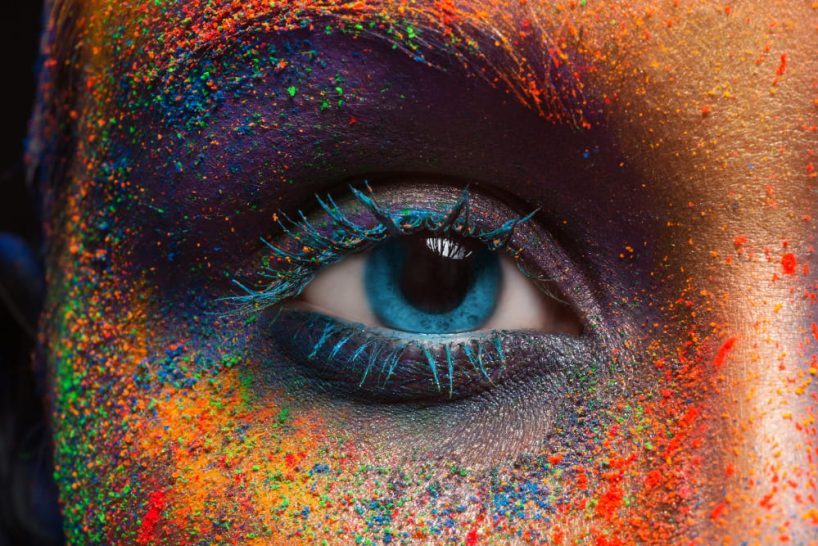 Human eye with coloured powder all around.