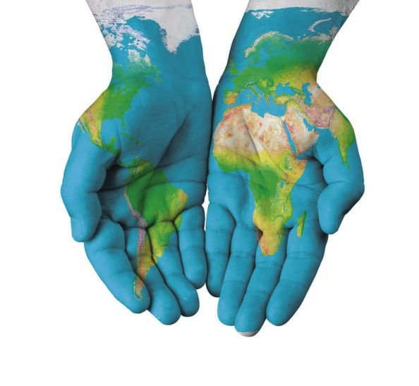 Coloured hands with a stylised world map as symbol.