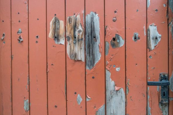 Peeling paint on a wooden door.