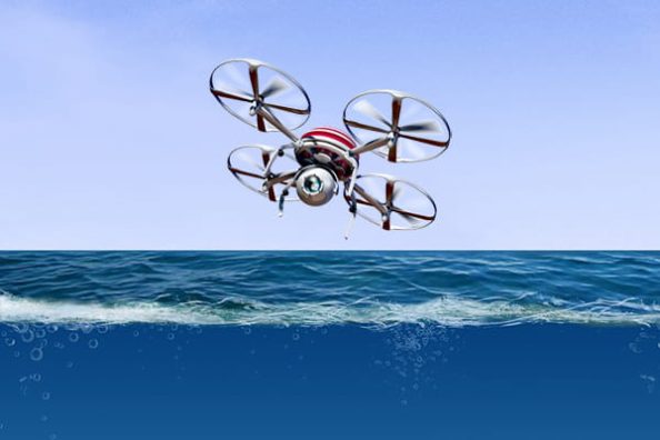 A quadrocopter drone above sea level; the underwater area is visible. Symbol image.